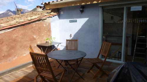 a patio with a table and chairs on a balcony at La Parenthèse - toit terrasse in Die