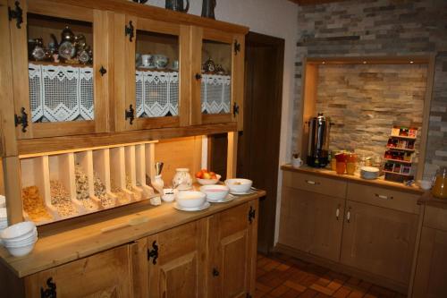 a kitchen with wooden cabinets and dishes on a counter at Pension Schusterpeter in Bad Tölz
