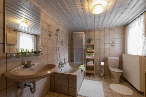 La salle de bains est pourvue d'un lavabo, d'une baignoire et de toilettes. dans l'établissement Ferienwohnung Rehkoglgut, à Bad Goisern