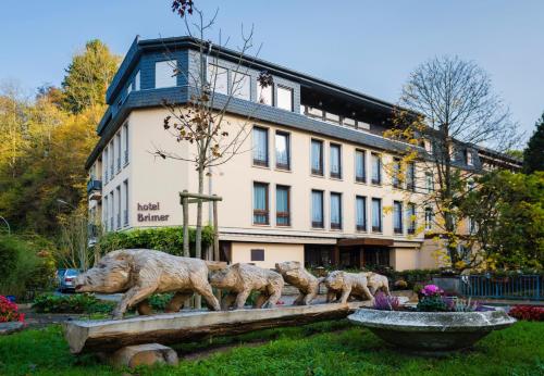 a statue of three sheep in front of a building at Hotel Brimer in Grundhof
