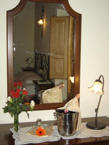 a table with a vase of flowers and a mirror at Ai Vecchi Crateri in SantʼAlfio