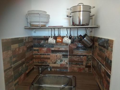 cocina con pared de ladrillo y fregadero en Villa Ateni, en Gavrion