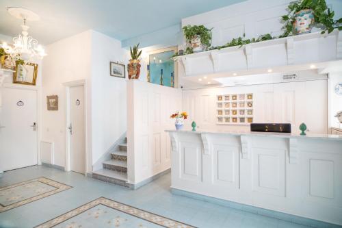 
a kitchen with a white counter top and white cabinets at Hotel Villa Nefele in Giardini Naxos
