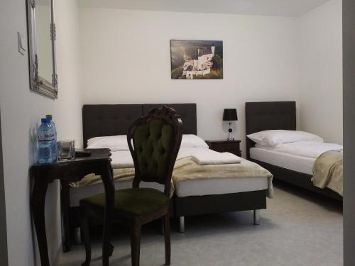 チェンストホヴァにあるDom Jurajskiのベッドルーム1室(ベッド2台、テーブル、椅子付)