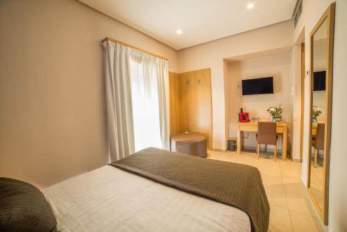 a bedroom with a bed and a desk and a window at Airone Hotel in Naples