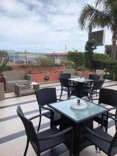 een patio met tafels en stoelen op een dak bij Hotel Hermitage in Qualiano