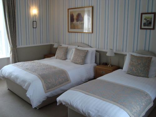 una camera d'albergo con due letti e due lampade di Willowbank a Grantown on Spey