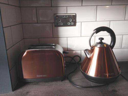 a tea kettle is sitting next to a toaster at Caledonian Canal Studio in Inverness