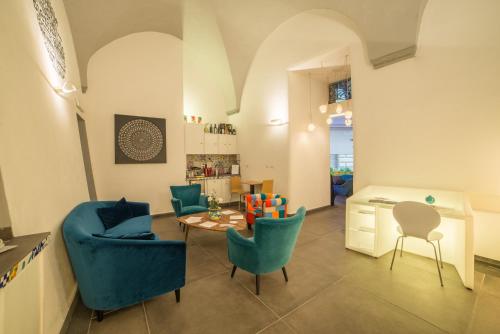 a living room with blue chairs and a table at Airone Hotel in Naples