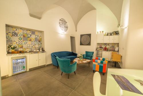 a living room with a table and blue chairs at Airone Hotel in Naples