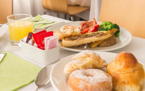 two plates of breakfast food on a table at Airone Hotel in Naples