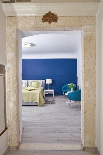 a bedroom with a blue wall and a bed at Apartments Giron in Dubrovnik
