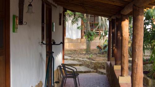 a chair sitting outside of a house with a porch at Hotel Finca Buenos Aires Barichara in Barichara