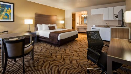 a hotel room with a bed and a kitchen at Best Western Heritage Inn in Concord