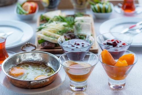 a table topped with bowls and plates of food at Assos Kartal Yuvasi Hotel in Sazlı