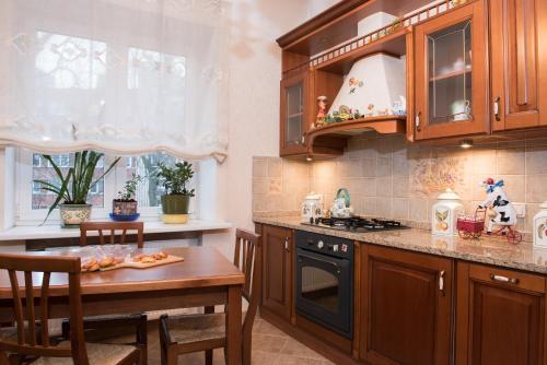 a kitchen with wooden cabinets and a table and a stove at Classy apartment in good neighbourhood in Riga