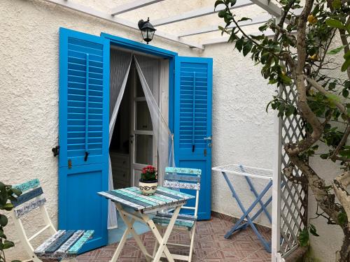 a blue door with a table and chairs outside at La Casa del Limoneto in Favignana