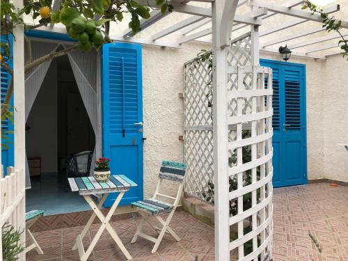 a patio with blue doors and a table and a chair at La Casa del Limoneto in Favignana