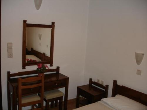a bedroom with a mirror and a bed and a desk at Elena Studios in Chania