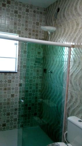 a bathroom with a shower with a glass shower backdoor at Casa temporada in Arraial do Cabo