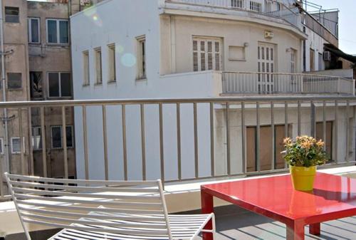a red table and chairs on a balcony at A for Athens in Athens