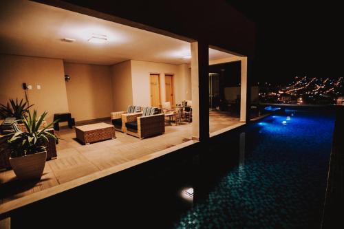 a house with a swimming pool at night at Hotel Amantykir in Itajubá