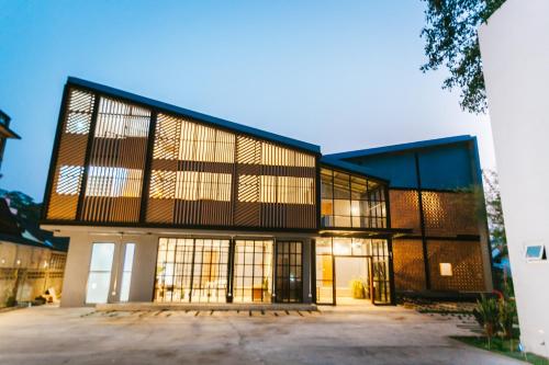 an exterior view of a building with large windows at Hug Inn Phrae in Phrae