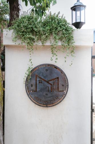 a sign on a wall with a clock on it at Hug Inn Phrae in Phrae