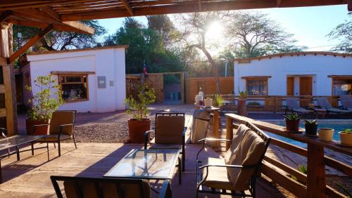 a patio with a table and chairs and a building at Hotel La Cochera in San Pedro de Atacama