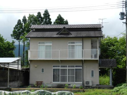 a house with a balcony on top of it at B&B Toyonoakari in Taragi