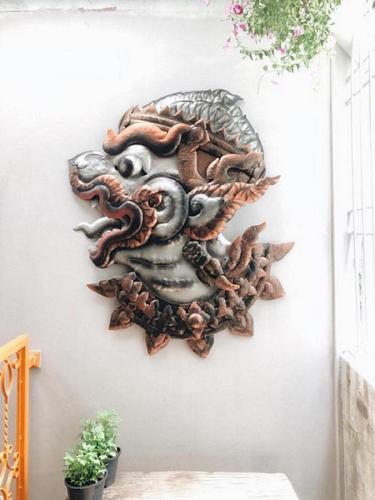 a wooden dragon wall decoration on a wall at Stash in Bangkok