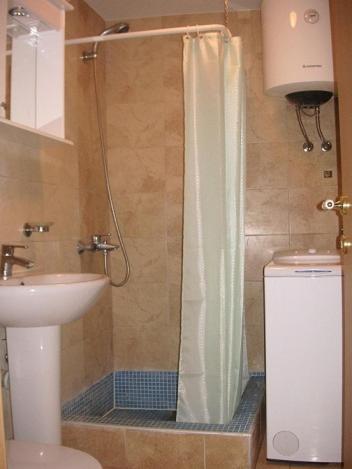 a bathroom with a shower with a toilet and a sink at House on the beach in Kotor