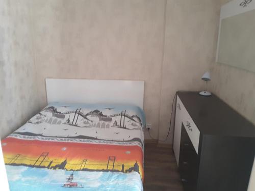 a small bedroom with a bed and a dresser at Orbi Plaza Apartment in Batumi