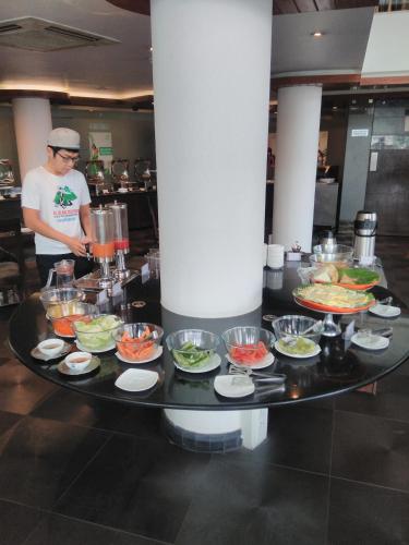 a man standing in a kitchen with a table of food at Melange Astris in Bengaluru