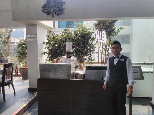 a man standing in front of a kitchen with a chef at Melange Astris in Bengaluru