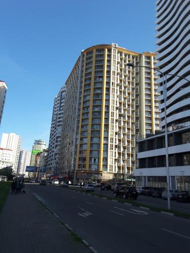 a large building with cars parked on the side of a street at Orbi Plaza Apartment in Batumi