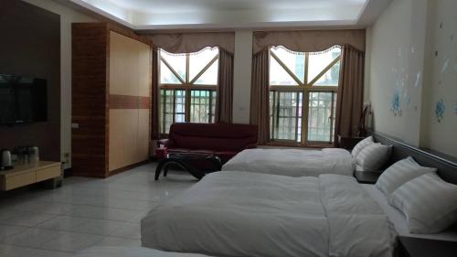 ein Hotelzimmer mit zwei Betten und einer Couch in der Unterkunft Lianhangiu Homestay in Taitung