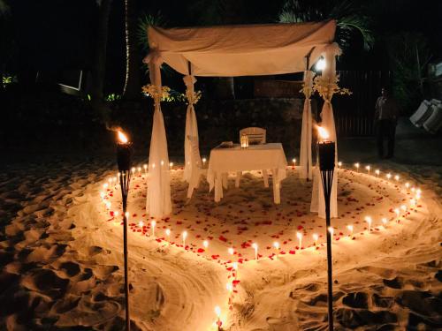 a wedding altar with candles in the sand at night at Erawan Villa Hotel in Bangrak Beach