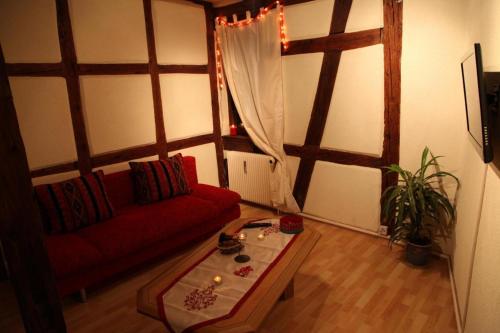 a living room with a red couch and a table at La Grenouille in Turckheim