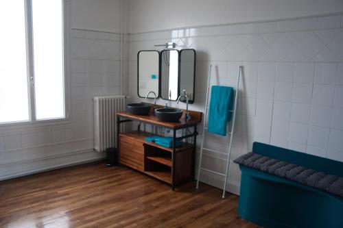 a bathroom with two sinks and a mirror at L'Iliade - Chambres d'hôtes - B&B à Bouzy in Bouzy