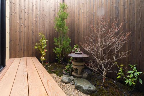 a garden with a bird bath in front of a fence at Inari Ohan in Kyoto