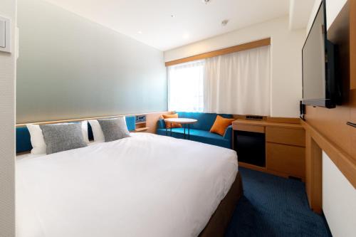 una camera d'albergo con letto e TV di Nishitetsu Inn Nihonbashi a Tokyo