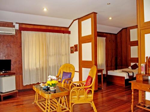 a living room with chairs and a table and a bed at KMA Bagan Hotel River View in Bagan