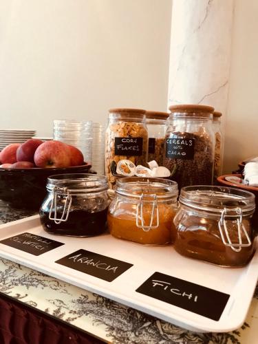 a tray with jars of jam and apples on a counter at Hotel Al Sole in Preganziol