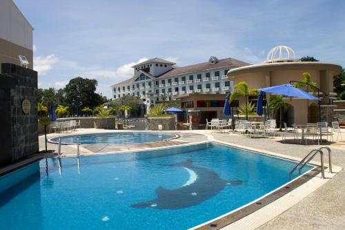 a large swimming pool with a hotel in the background at Klana Beach Resort Port Dickson in Port Dickson