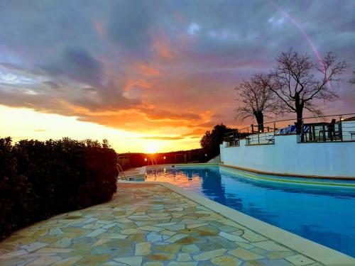 a view of a swimming pool with a sunset in the background at Borgo La Casaccia in Montaione