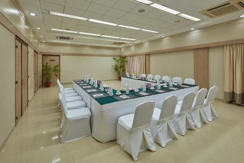 a large conference room with a long table and white chairs at Royal Orchid Beach Resort & Spa, Utorda Beach Goa in Utorda
