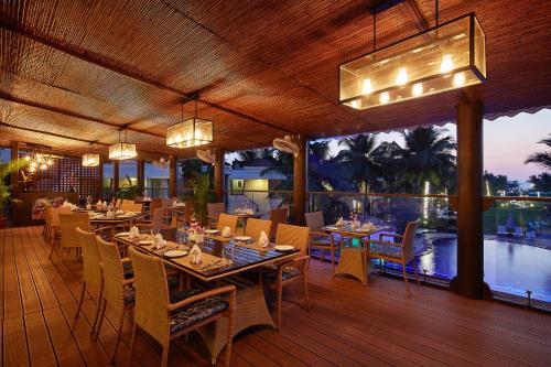 a restaurant with tables and chairs on a deck at Royal Orchid Beach Resort & Spa, Utorda Beach Goa in Utorda