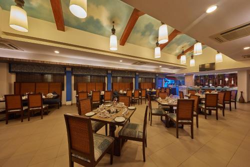 a dining room with tables and chairs in a restaurant at Royal Orchid Beach Resort & Spa, Utorda Beach Goa in Utorda