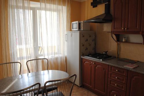 ヴィーンヌィツャにあるАпартаменты на Магистрацкой Центрのキッチン(テーブル、白い冷蔵庫付)